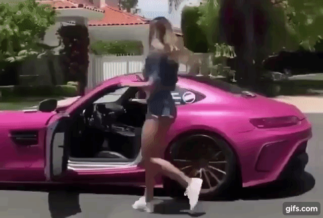 cô gái tóc vàng nhảy theo điệu nhạc bên ngoài siêu xe